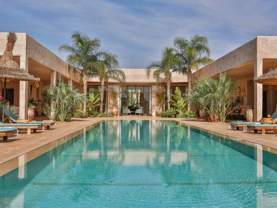 Villa avec grande piscine, palmiers et transats