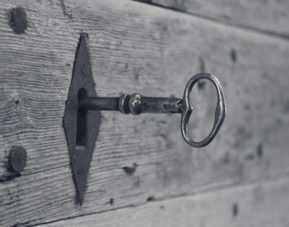 Clé ancienne engagée dans une serrure sur une porte en bois